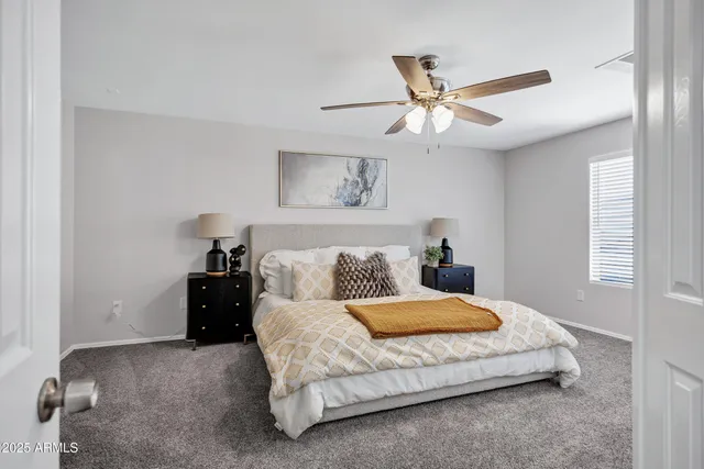 a bedroom with a large bed and a ceiling fan