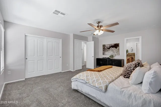 a spacious bedroom with a bed and a chandelier