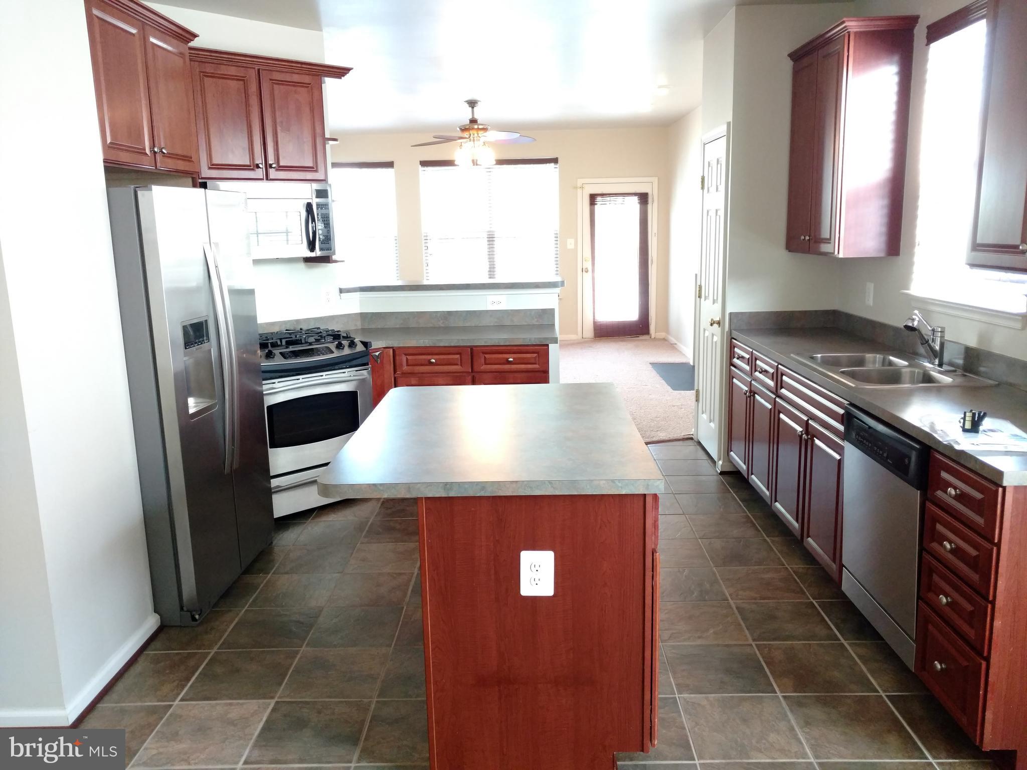 8378 Tillett Loop Manassas, VA 20110 - Photo 2 of 24 a kitchen with stainless steel appliances granite countertop a stove a refrigerator and a sink