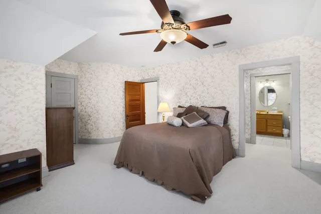 a bedroom with a bed and a ceiling fan