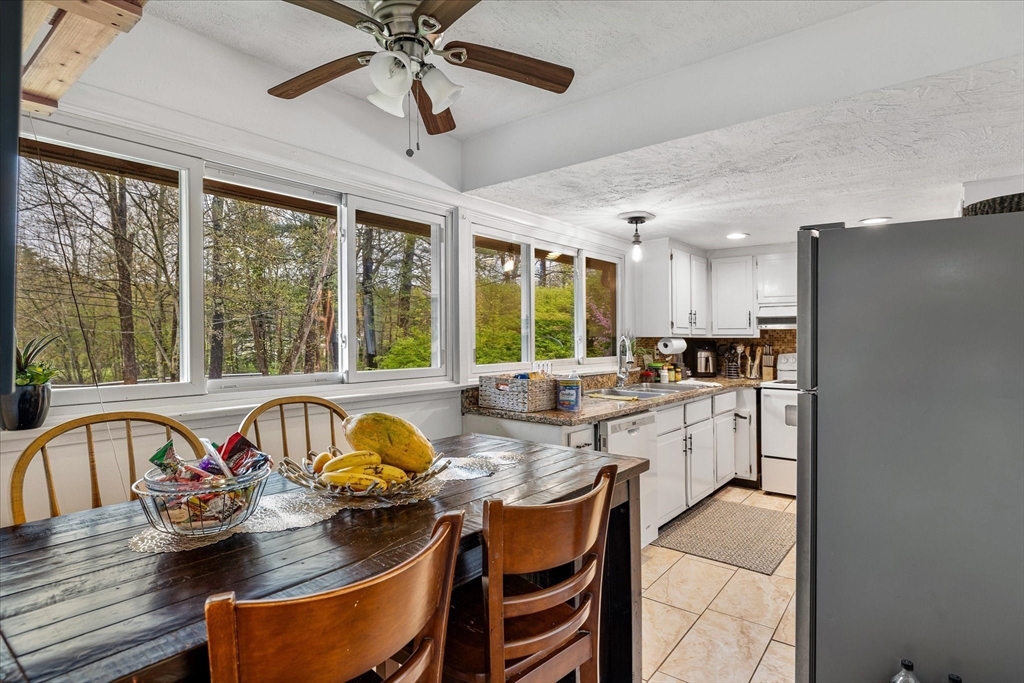 240 Worcester Road Barre, MA 01005 - Photo 19 of 38 a kitchen with stainless steel appliances granite countertop a stove refrigerator a dining table and chairs with a large window