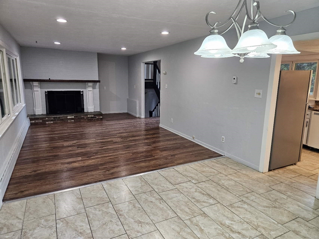 240 Worcester Road Barre, MA 01005 - Photo 35 of 38 an empty room with wooden floor fireplace and windows