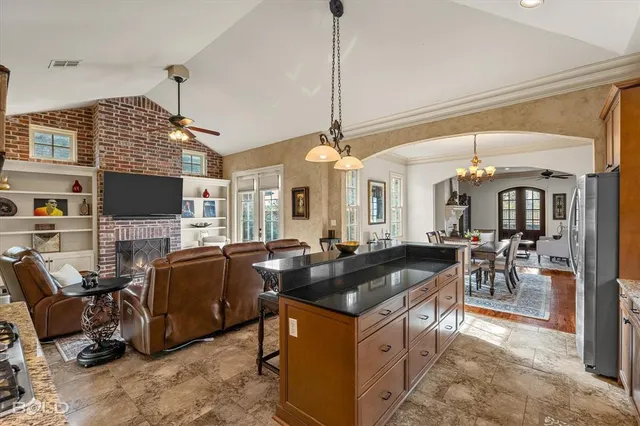 a living room with furniture a flat screen tv and kitchen view