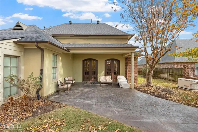 a view of a house with large windows and a tree
