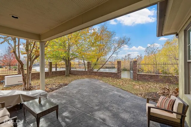 a view of a porch with couches and table and chairs next to yard
