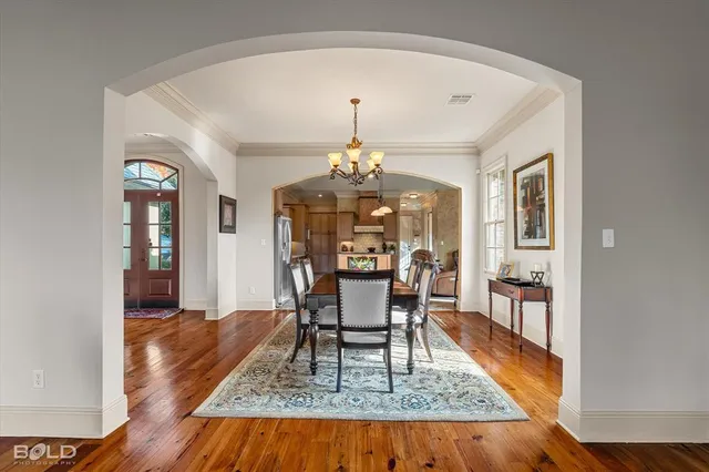 a dining room with furniture a chandelier and wooden floor