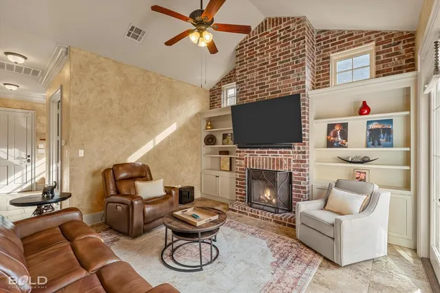 a living room with furniture a fireplace and a flat screen tv