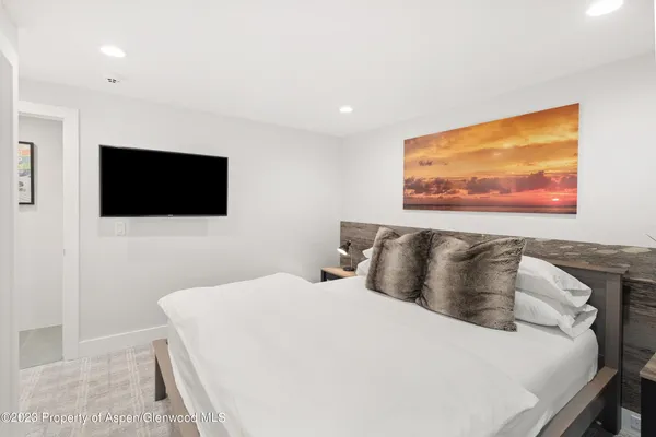 a bedroom with a bed and a flat screen tv