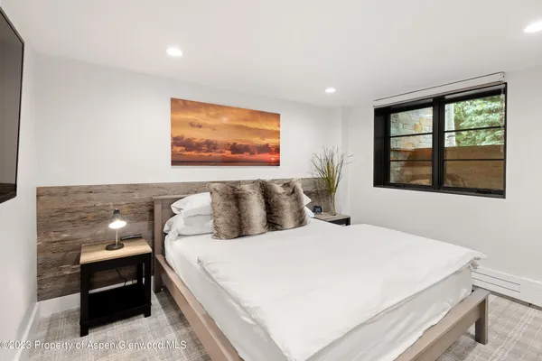 a large bed sitting in a bedroom next to a window