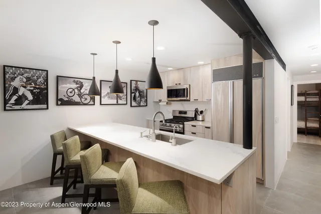 a kitchen with stainless steel appliances a sink a counter top space cabinets and wooden floor