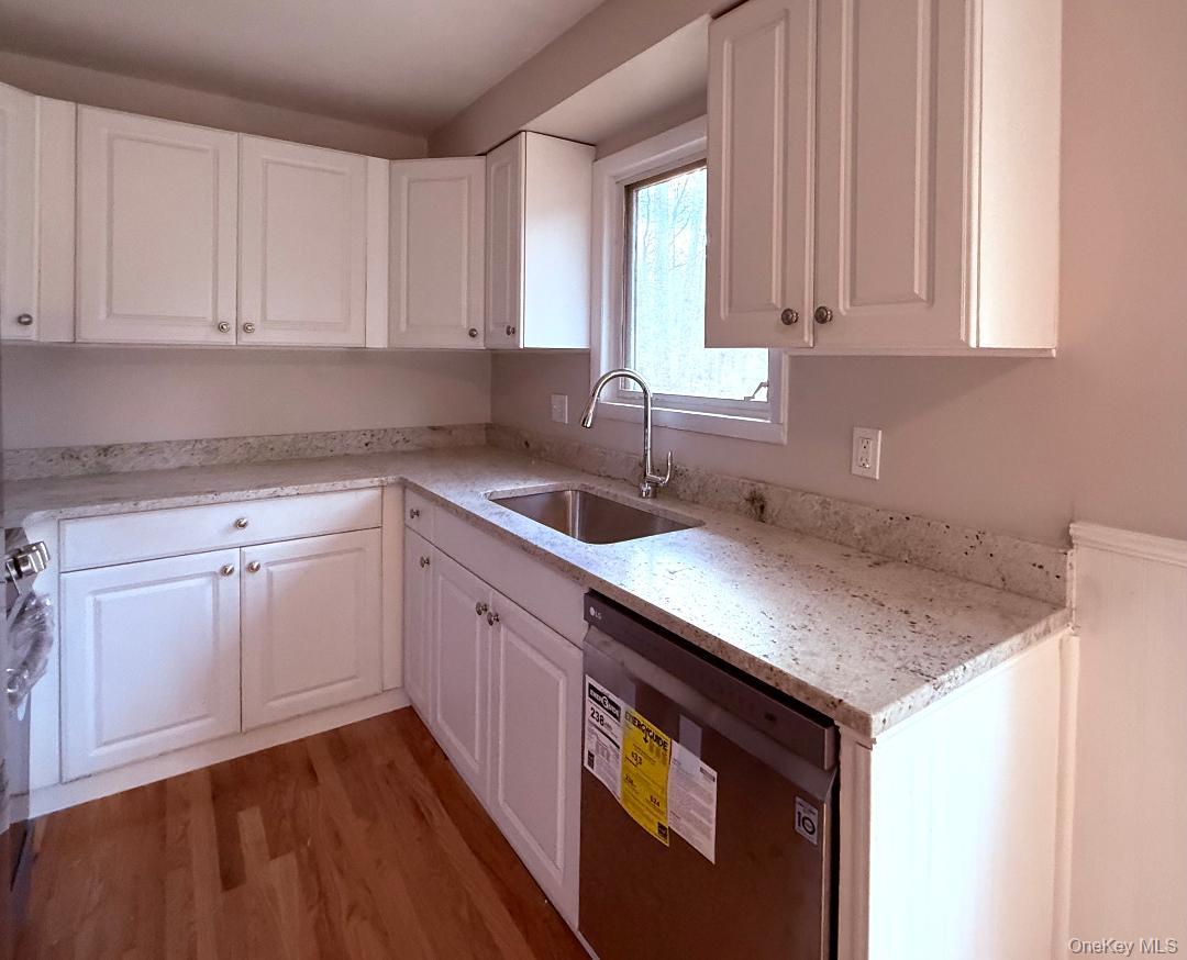 200 Belvedere Road Beacon, NY 12508 - Photo 5 of 23 Kitchen with hardwood / wood-style flooring, white cabinetry, sink, dishwashing machine, and light stone counters
