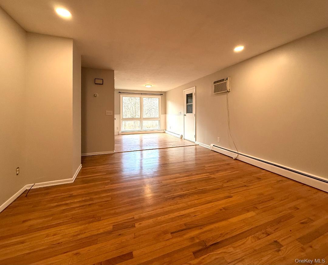 200 Belvedere Road Beacon, NY 12508 - Photo 9 of 23 Empty room featuring baseboard heating, light hardwood / wood-style floors, and a wall unit AC