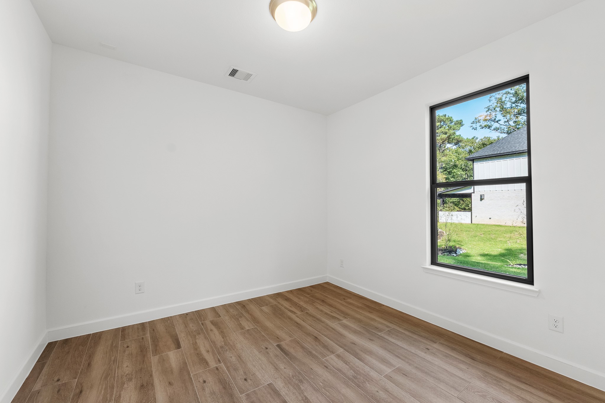 205 Tall Pine Livingston, TX 77351 - Photo 25 of 42 a view of an empty room with wooden floor and a window