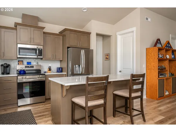 a kitchen with stainless steel appliances a stove a sink refrigerator and a microwave