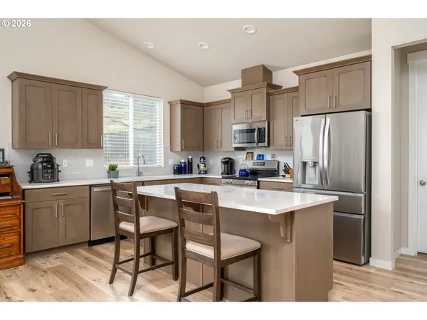 a kitchen with kitchen island a sink stove and refrigerator