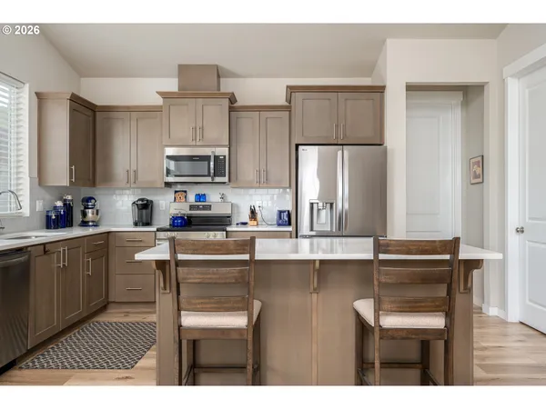 a kitchen with stainless steel appliances granite countertop a refrigerator and microwave