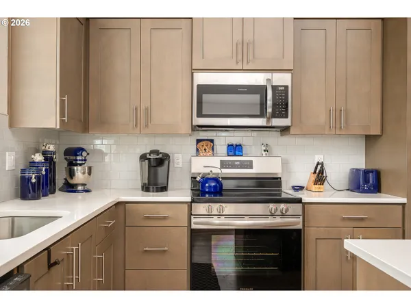 a kitchen with stainless steel appliances granite countertop a sink a stove a microwave and cabinets