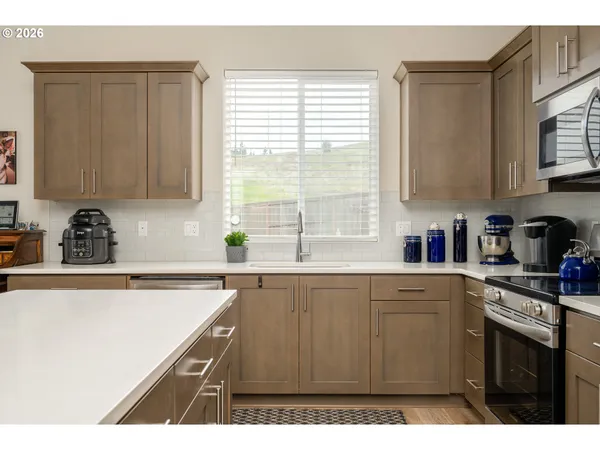 a kitchen with stainless steel appliances granite countertop a sink a stove and a refrigerator