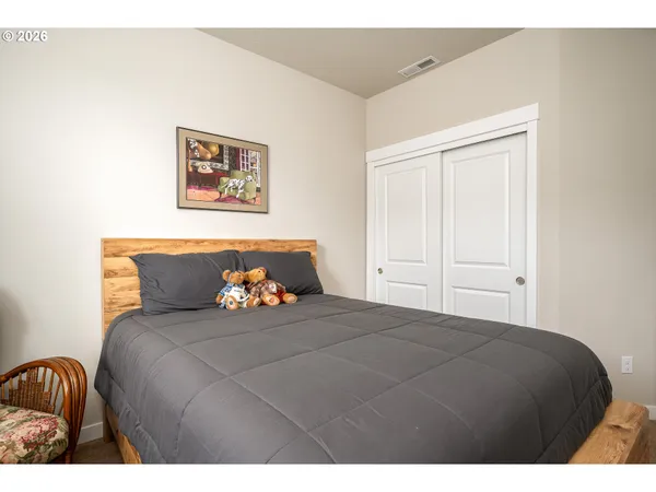 a bedroom with a bed and painting on the wall