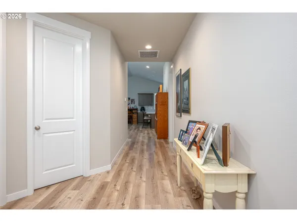 a hallway with a large mirror and dresser