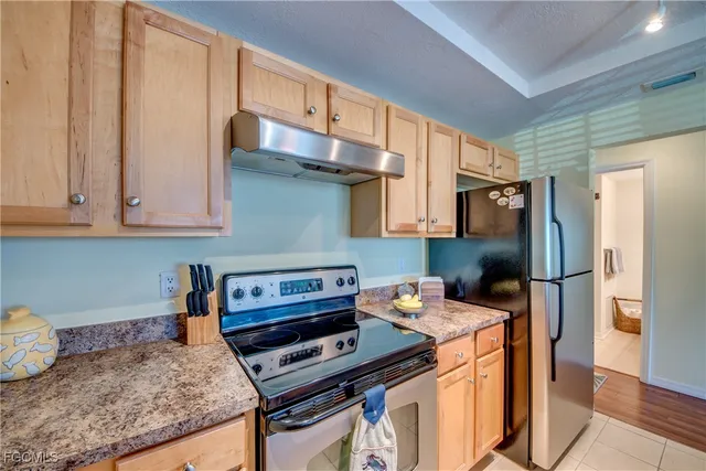 a kitchen with stainless steel appliances granite countertop a refrigerator and a stove top oven