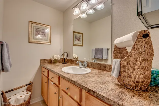a bathroom with a granite countertop sink a mirror and vanity