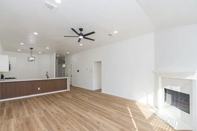 a view of room with wooden floor and a ceiling fan