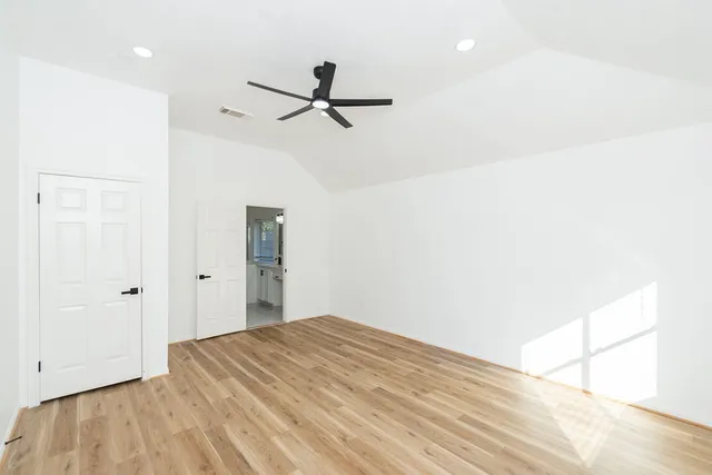 a view of a room with a ceiling fan and wooden floor
