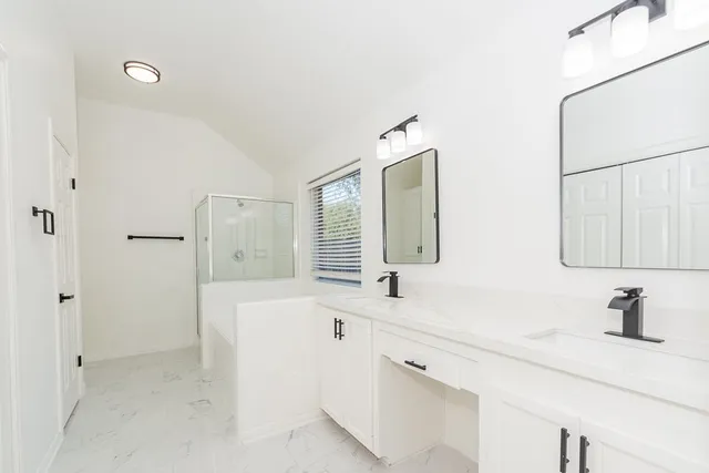 a bathroom with a double vanity sink mirror and shower