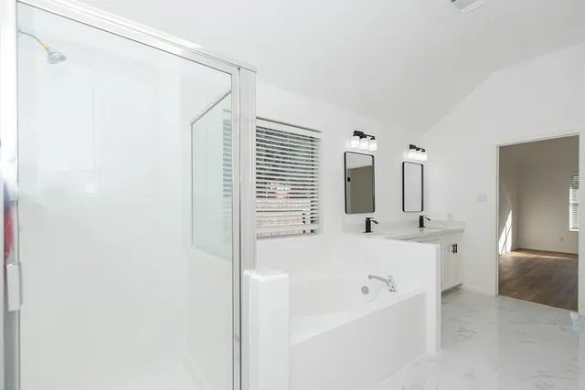 a bathroom with a tub sink and mirror