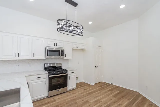 a kitchen with a stove and white cabinets