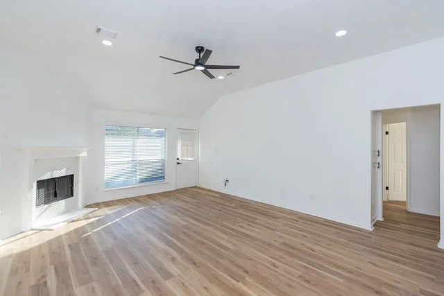 a view of empty room with wooden floor and fireplace