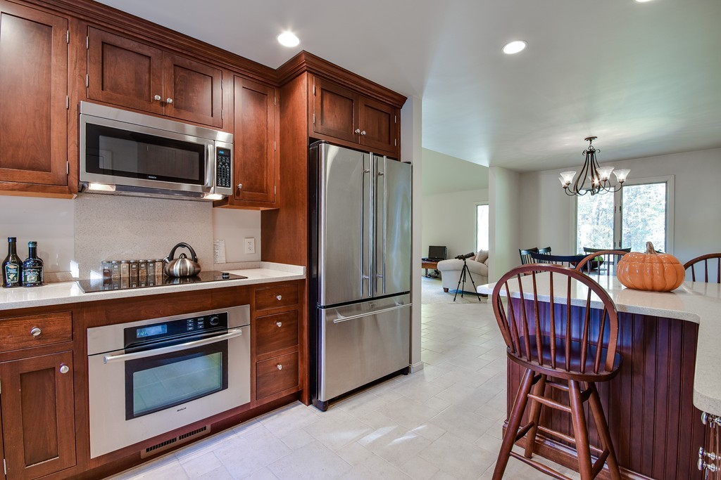 7 Steepletree Lane, Unit 7 Wayland, MA 01778 - Photo 3 of 22 a kitchen with stainless steel appliances granite countertop a stove microwave and refrigerator