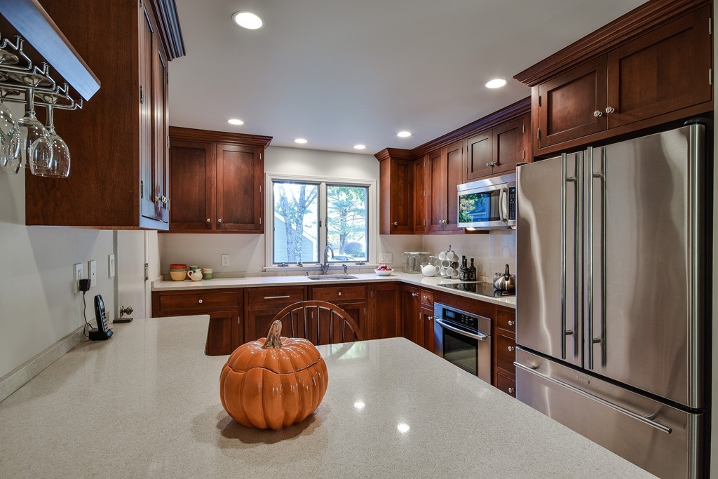 7 Steepletree Lane, Unit 7 Wayland, MA 01778 - Photo 4 of 22 a kitchen with stainless steel appliances granite countertop a refrigerator a sink a stove and cabinets