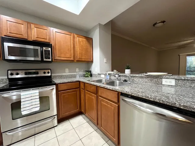 a kitchen with stainless steel appliances granite countertop a sink stove and microwave