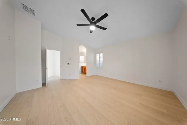 a view of a livingroom with a ceiling fan & window