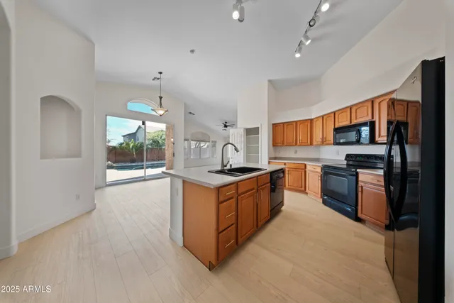 a large kitchen with stainless steel appliances granite countertop a stove and a sink