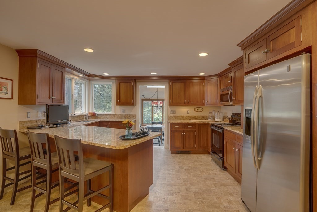 35 Wilson Road Bedford, MA 01730 - Photo 3 of 42 a kitchen with stainless steel appliances granite countertop a stove refrigerator sink and cabinets