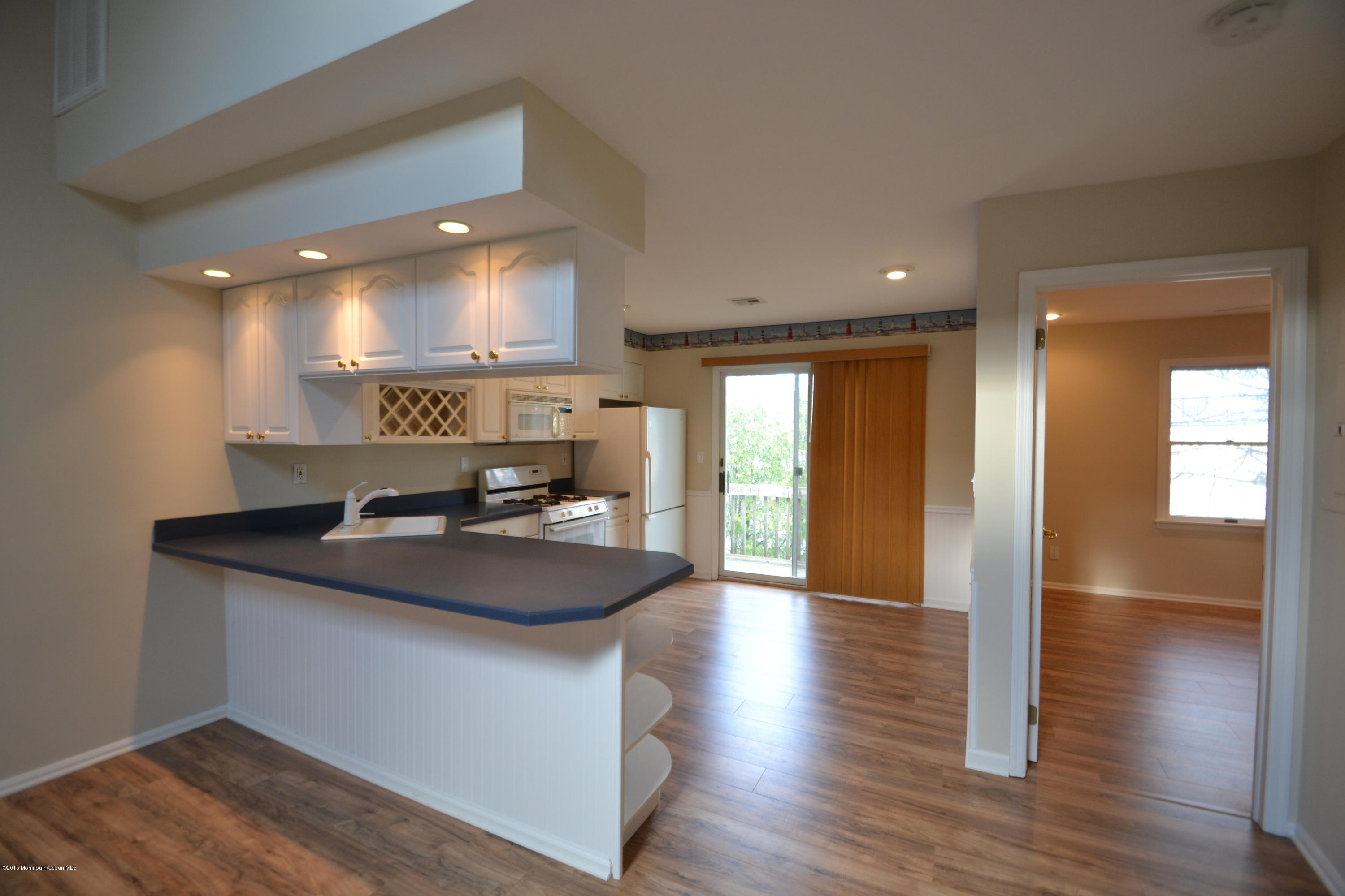 1212 Beaver Dam Road, Unit 14 Point Pleasant, NJ 08742 - Photo 4 of 14 a kitchen with stainless steel appliances granite countertop a sink a stove and a wooden floor