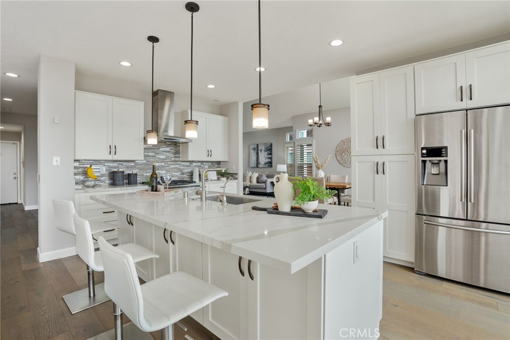 29632 Alta Terra Laguna Niguel, CA 92677 - Photo 18 of 37 a kitchen with stainless steel appliances kitchen island granite countertop a table chairs and a refrigerator