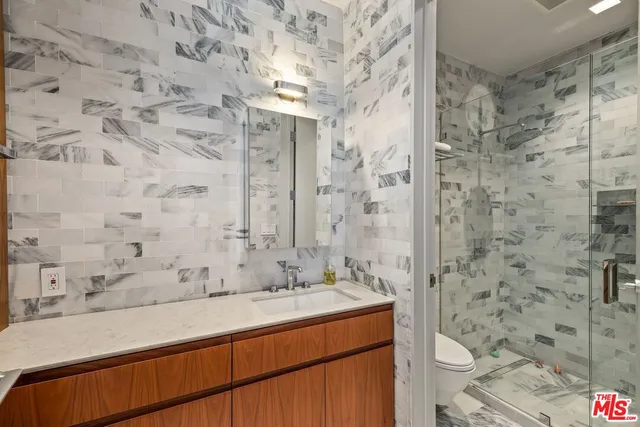 a bathroom with a sink mirror vanity and toilet