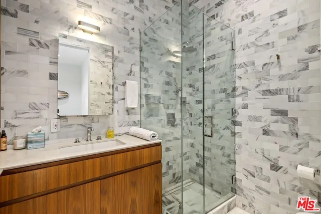 a bathroom with a sink mirror and shower