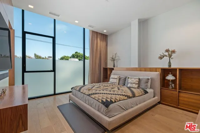 a bedroom with a large bed and a chandelier