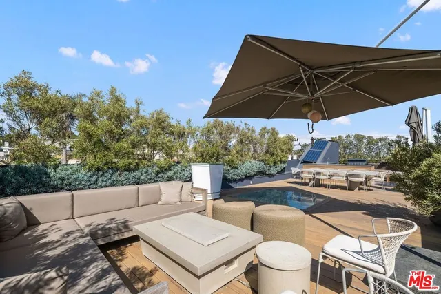 a view of a patio with a table and chairs under an umbrella