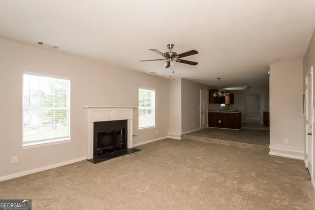 an empty room with fireplace and windows