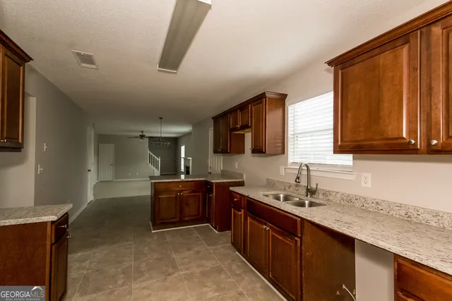 a kitchen with granite countertop a sink and a stove top oven
