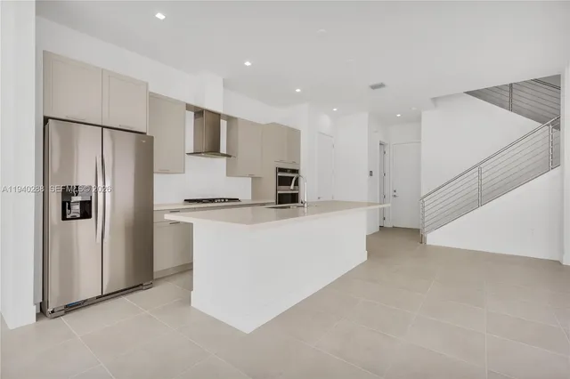 a view of kitchen with stainless steel appliances refrigerator stove microwave and cabinets