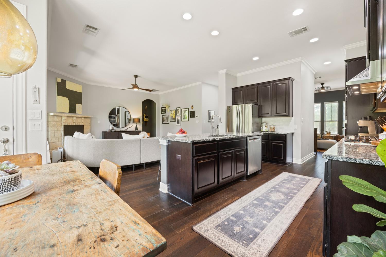 1135 Blue Ridge Drive Dripping Springs, TX 78620 - Photo 5 of 36 An open-concept design seamlessly blends the kitchen and living areas, highlighted by gleaming hardwood flooring.