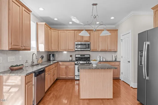 a kitchen with stainless steel appliances granite countertop a stove a sink dishwasher and a refrigerator