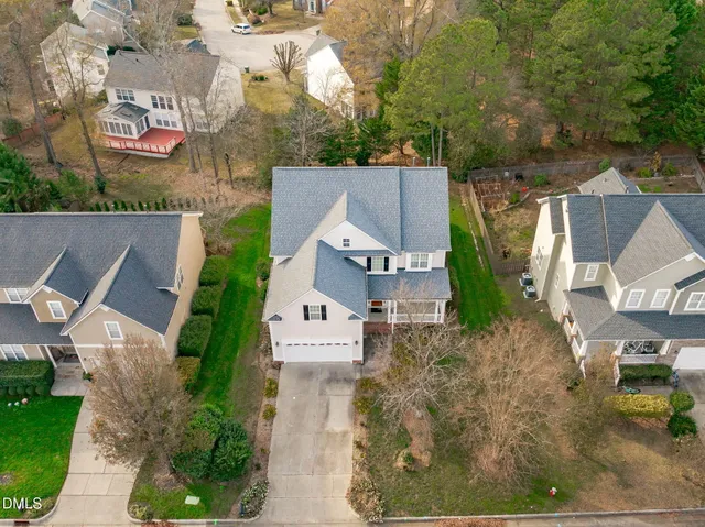 an aerial view of residential house with outdoor space and trees all around